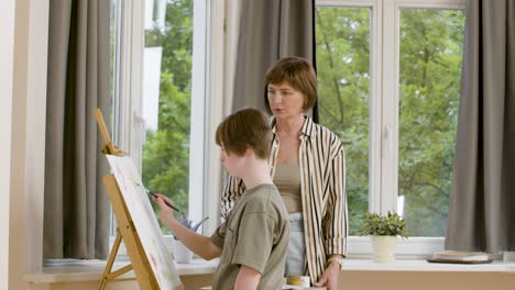 Mature-woman-and-her-daughter-painting-at-home