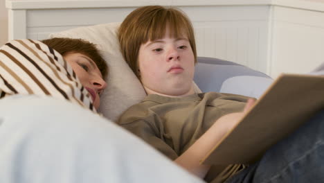 Teenager-reading-magazine-on-bed-with-her-mother