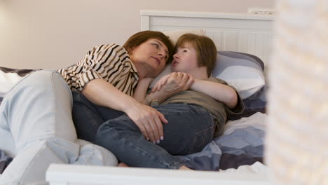 Young-girl-talking-with-her-mother-on-the-bed
