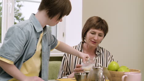 Mother-having-conversation-with-her-daughter-while-is-serving-milk