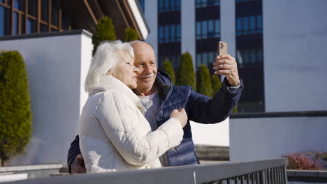 Senior-couple-making-a-selfie-with-smartphone-in-the-park-on-a-winter-day