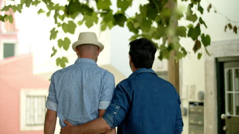 Back-view-of-gay-man-walking-with-boyfriend-and-hugging-his-waist