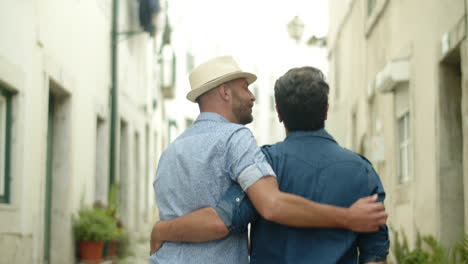 Gay-couple-hugging-each-others-waist-and-walking-around-city