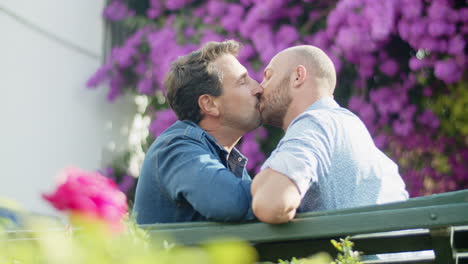Slow-motion-of-gay-couple-sitting-and-hugging-on-bench-in-park