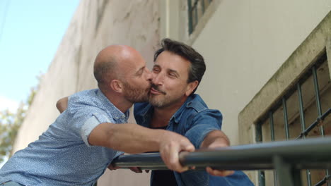 Happy-gays-kissing-and-holding-on-to-railing-of-stairs