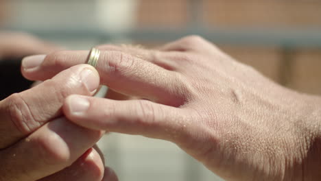 Close-up-shot-of-gay-putting-wedding-ring-on-lover's-finger