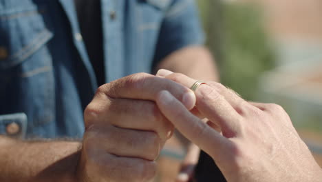 Slow-motion-of-man-putting-engagement-ring-on-boyfriend's-finger