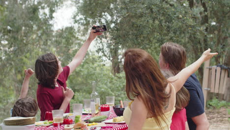 Young-Caucasian-boy-taking-selfie-with-his-family-during-outdoor-dinner