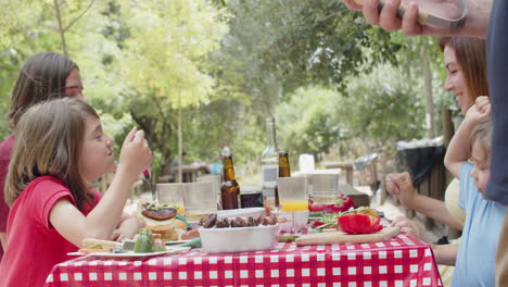 Slider-shot-of-happy-family-eating-delicious-food-at-picnic