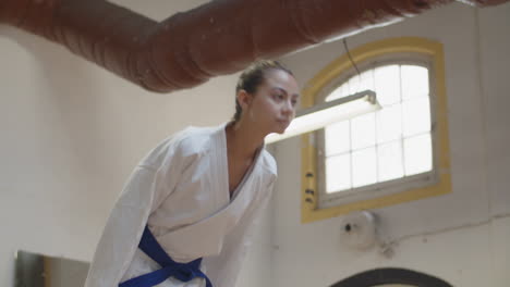 Slider-shot-of-girl-bowing-before-starting-karate-workout