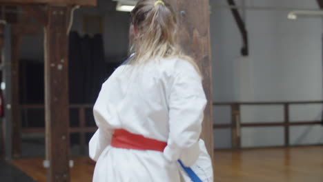 Handheld-shot-of-happy-girls-practicing-karate-together-in-gym