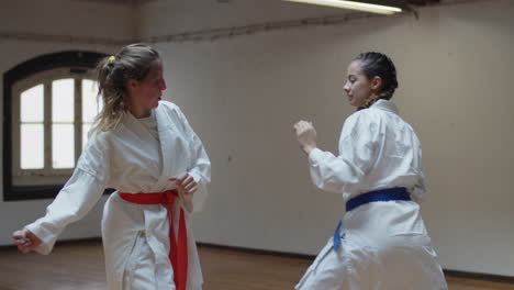 Tracking-shot-of-serious-girls-in-kimonos-fighting-in-gym