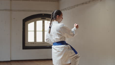 Tracking-shot-of-focused-girl-performing-karate-movements