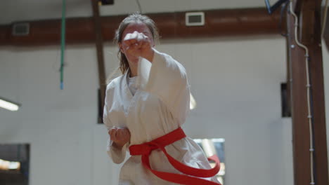 Tiro-Medio-De-Adolescente-Enfocado-Practicando-Karate-En-El-Gimnasio