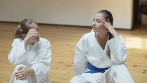 Slow-motion-of-girls-in-kimonos-talking-in-gym-after-training