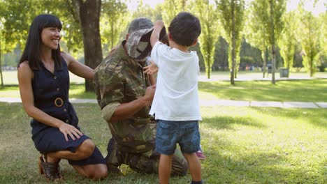 Happy-dad-wearing-military-uniform,-having-fun-with-his-wife-and-kids-at-the-park