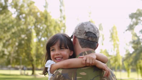 Military-dad-carrying-daughter-in-arms-in-the-park