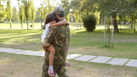 Strong-military-dad-holding-daughter-in-arms