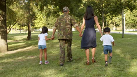 Military-man-and-his-family-enjoying-leisure-time-in-park