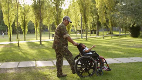 Military-dad-walking-with-daughter-in-wheelchair-and-son-at-the-park