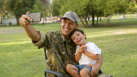 Feliz-Padre-Militar-Discapacitado-En-Silla-De-Ruedas-Tomando-Selfie-Con-Su-Hijo