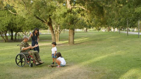 Disabled-military-dad-helping-children-with-logs-outdoors