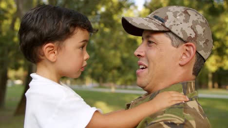 Papá-Militar-Feliz-Sosteniendo-A-Su-Pequeño-Hijo-En-Brazos