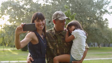 Happy-military-couple-of-parents-and-daughter-taking-selfie