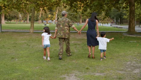 Military-man-enjoying-leisure-time-in-park-with-his-family