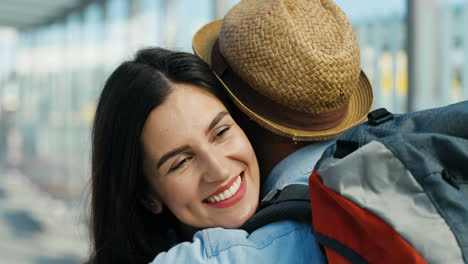 Close-up-view-of-happy-Caucasian-young-couple-meeting-at-train-station-and-hugging-on-nice-summer-day