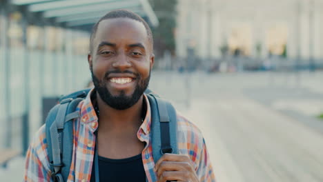 Close-up-view-of-african-american-man-traveller-smiling-and-looking-at-camera-at-bus-station