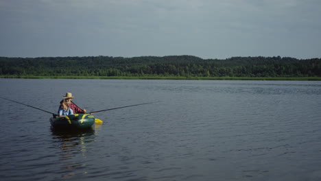 Aerial-view-of-grandfather-and-grandson-floating-on-the-boat-on-the-picturesque-river-on-a-summer-day