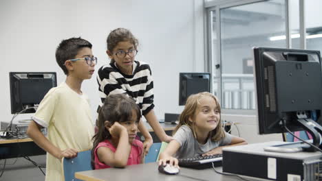 Niños-Multiétnicos-Mirando-El-Monitor-De-La-Computadora-Durante-La-Lección-De-Informática