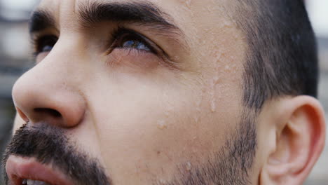Close-up-view-of-caucasian-bearded-man-looking-the-sky-with-drops-of-sweat-on-his-face-and-then-looks-at-the-camera