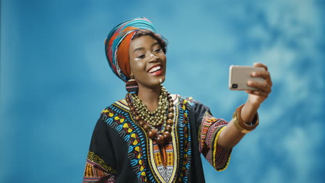 Afroamerikanische-Junge-Schöne-Frau-In-Traditioneller-Kleidung-Und-Turban,-Die-Ein-Selfie-Mit-Smartphone-Macht
