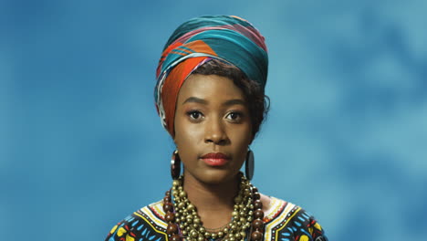 Afroamerikanische-Junge-Frau-In-Turban-Und-Traditioneller-Kleidung,-Die-Mit-Ernstem-Ausdruck-In-Die-Kamera-Schaut