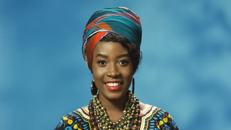 Nahaufnahme-Einer-Afroamerikanischen-Jungen-Frau-In-Turban-Und-Traditioneller-Kleidung,-Die-Lächelt-Und-In-Die-Kamera-Schaut