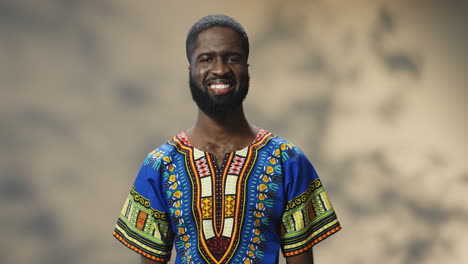 Porträt-Eines-Jungen-Fröhlichen-Afroamerikanischen-Mannes-In-Traditioneller-Kleidung,-Der-In-Die-Kamera-Lächelt