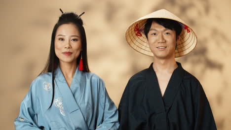 Asiatisches-Junges-Paar-In-Traditionellen-Chinesischen-Kostümen,-Die-In-Die-Kamera-Lächeln
