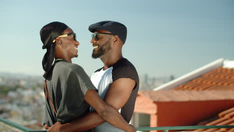 Side-view-of-smiling-Afro-American-gay-couple-hugging-on-rooftop