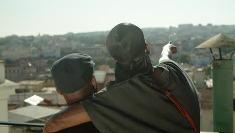 Back-view-of-gays-hugging-and-admiring-cityscape-from-rooftop