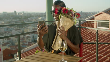 Happy-gay-having-video-call-with-lover-and-showing-him-flowers