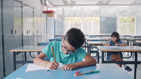 Niño-Alumno-Latino-Enfocado-Con-Gafas-Y-Escribiendo-En-Papel