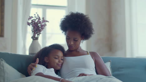 African-American-mother-and-daughter-lying-in-bed-and-relaxing-at-home
