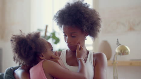 Loving-Black-woman-embracing-and-caressing-her-daughter-at-home
