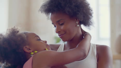 Loving-Black-woman-embracing-and-kissing-her-daughter-at-home