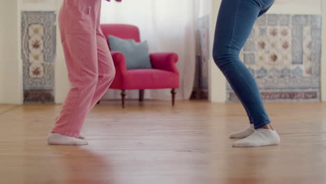 Legs-close-up-of-mum-and-daughter-dancing-at-home-in-white-socks