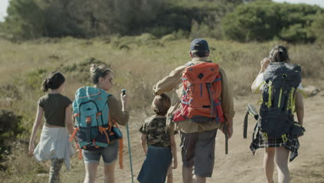 Back-view-of-Caucasian-family-with-backpacks-hiking-together