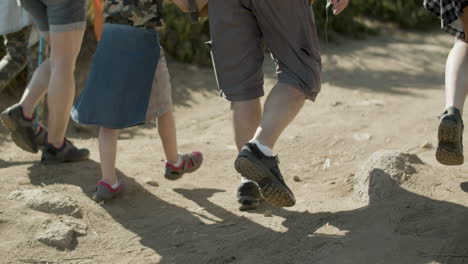 Legs-closeup-of-hiking-family-walking-along-dirt-road-together