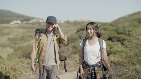 Front-view-of-father-and-daughter-with-backpacks-hiking-together